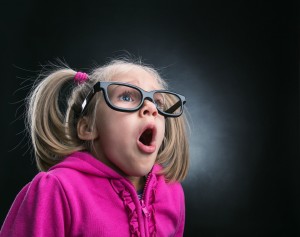 Little astonished girl in funny big spectacles